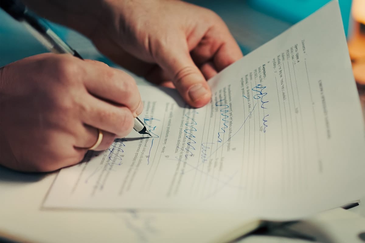 Personne signant un document officiel avec un stylo