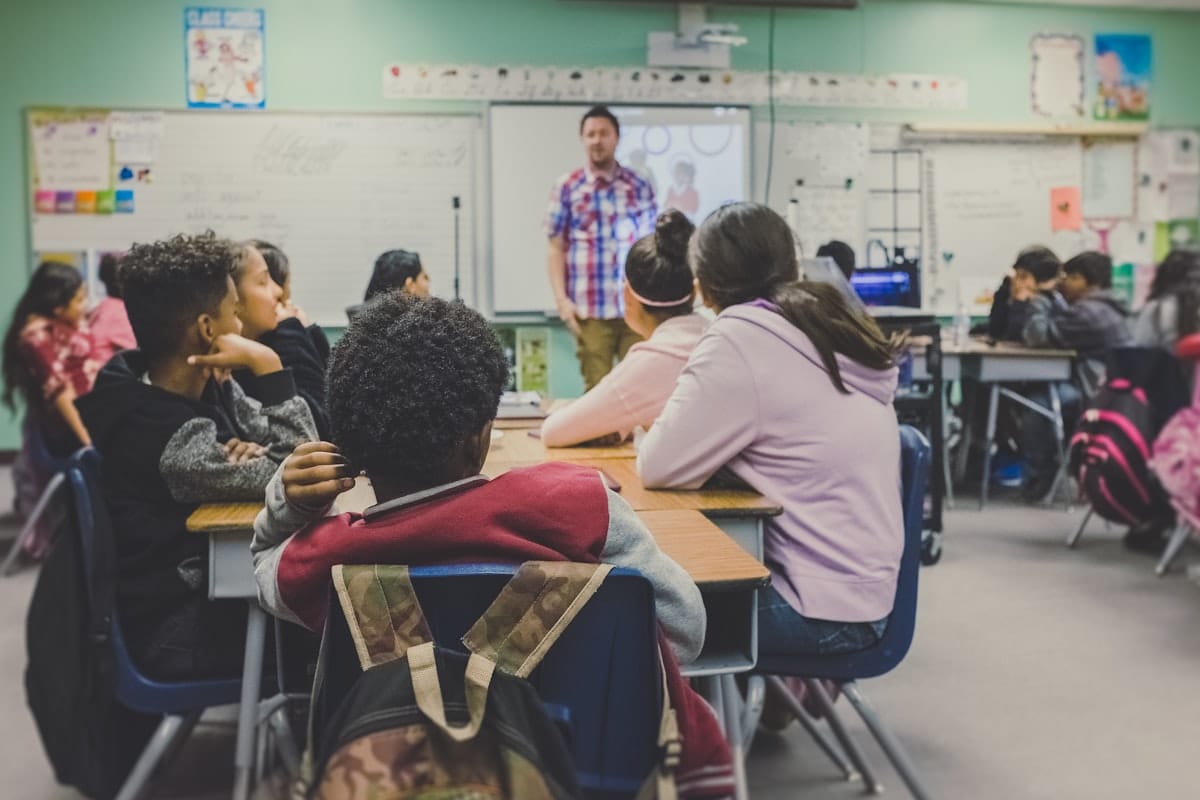 Enseignant présentant un cours devant des élèves attentifs dans une salle de classe